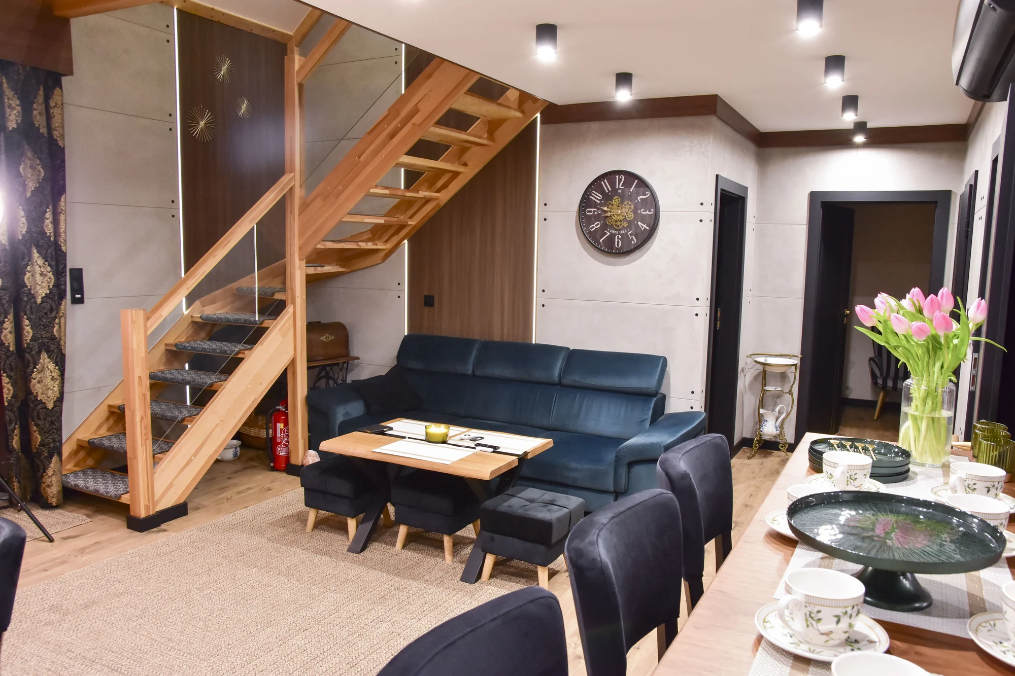 Salon 4A z granatową sofą przy drewnianych schodach